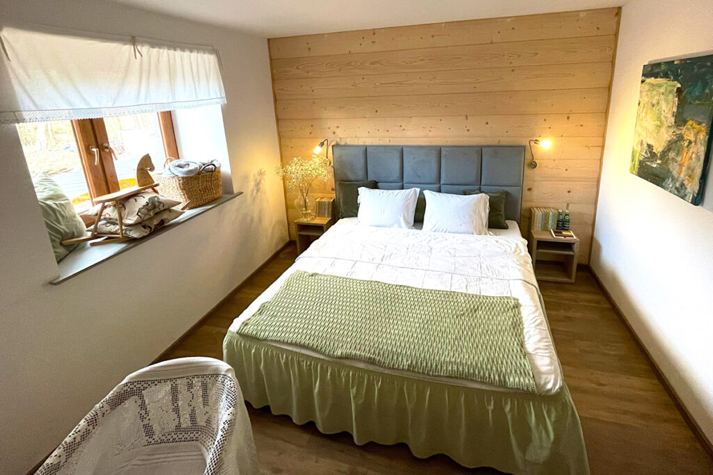 Zdjęcie ukazuje pokój hotelowy z dużym, dwuosobowym łóżkiem.
