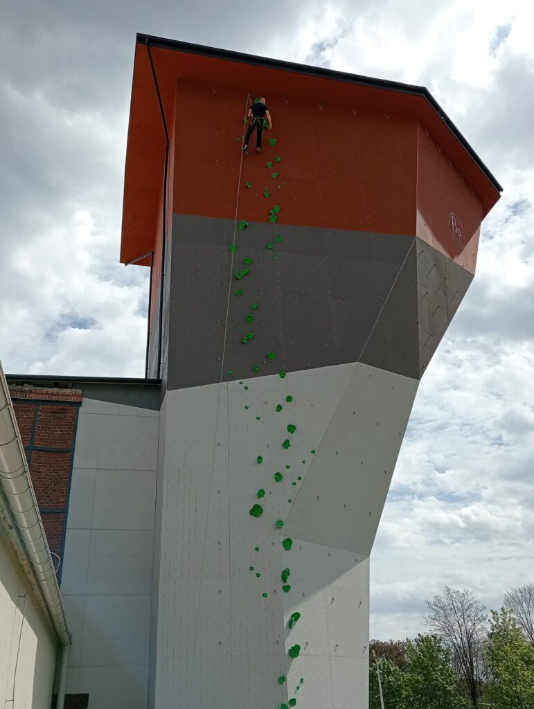 Zdjęcie przedstawia ścianę budynku, która podczas wydarzenia stanowiła ściankę wspinaczkową podczas wydarzenia. 