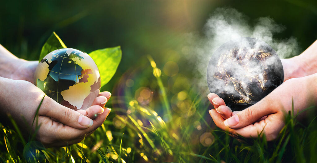 Ilustracją tekstu jest obraz przedstawiający dłonie wychodzące z prawej i lewej krawędzi grafiki. W dłoniach z lewej strony jest kula ziemska wśród liści, w tych z prawej strony widać dymiącą planetę.