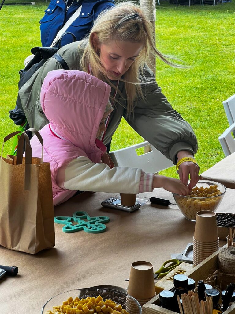 Kobieta z dziewczynką częstują się przysmakami.