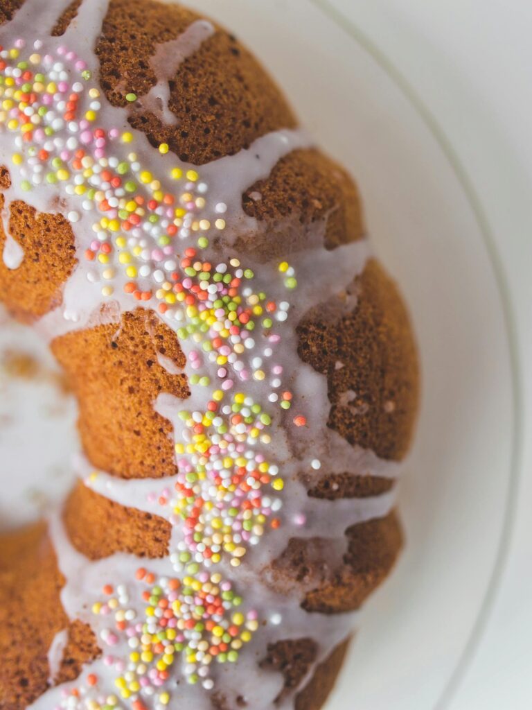 Puszysta babka piaskowa z lukrem i kolorową posypką jako przykład usług gastronomicznych, które wpisują się w definicję przemysłu czasu wolnego.